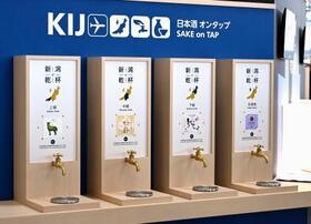　新潟空港で地元の日本酒や料理が楽しめる体験型ブース「新潟で乾杯」がオープンし、カウンターに設置された地酒を自分で注ぐ蛇口＝１９日午前