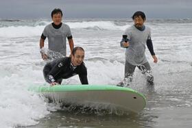 　障害者向けのサーフィン体験会で波に乗る片岡亮太さん＝３０日午前、福島県いわき市の薄磯海岸
