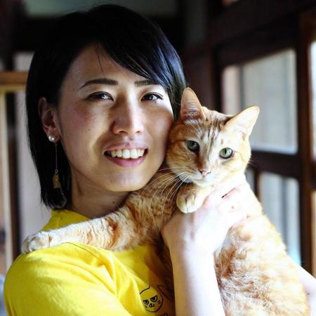 愛猫を抱く服部薫さん＝古賀市内