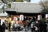 　参拝客でにぎわう伊奴神社。本社の横に白い犬の石像がある