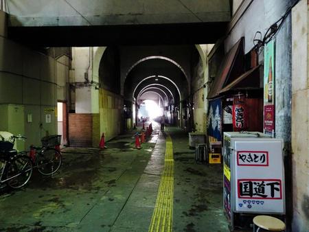 国道駅下のトンネル。真昼でも薄暗く、時間の止まった空間だが、右手前に唯一営業している居酒屋がある