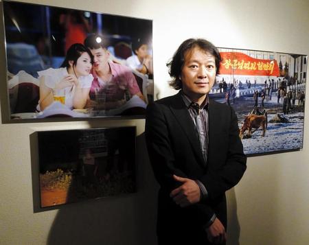 自作の前で北朝鮮の現実を語る写真家・初沢亜利さん＝東京・六本木の「山崎文庫」