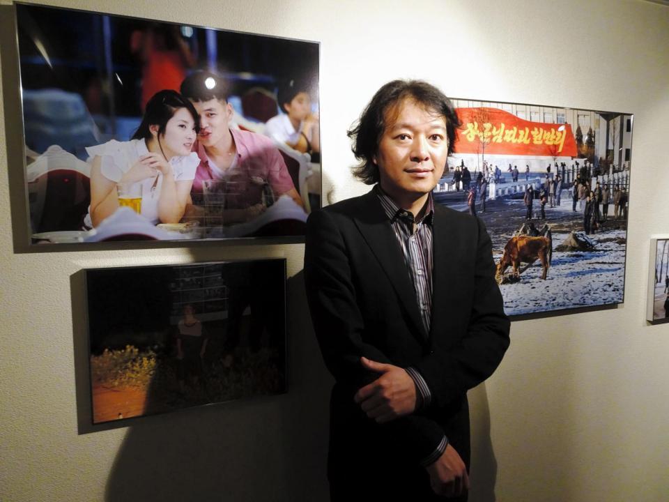 ８月まで開催中の写真展で北朝鮮の現実を語る初沢亜利さん＝東京・六本木の「山崎文庫」