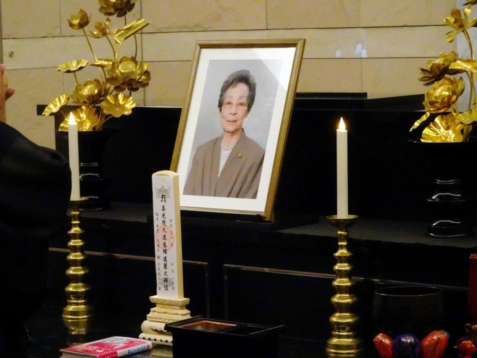井手久美子さんの遺影と位牌が置かれた祭壇。その前に著書が置かれた＝千葉県内