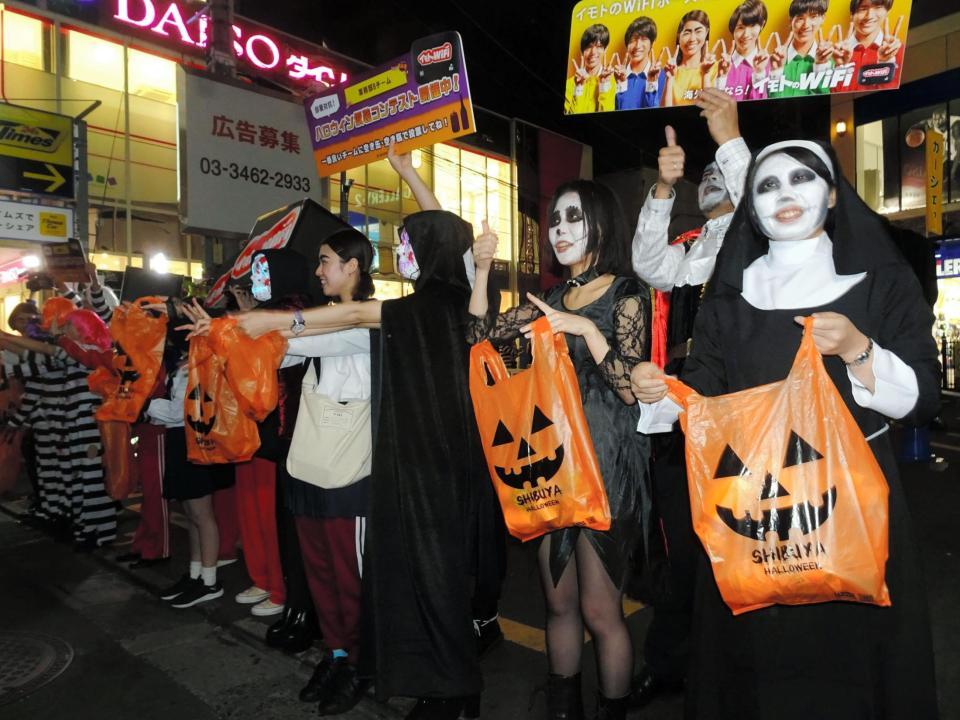 通行人にごみ捨てを呼びかける仮装した社員たち＝東京・渋谷