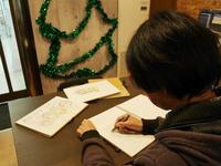 北神弓子カフェではファンが思い思いのときを過ごす。店内に用意されたスケッチブックにイラストを描く人も