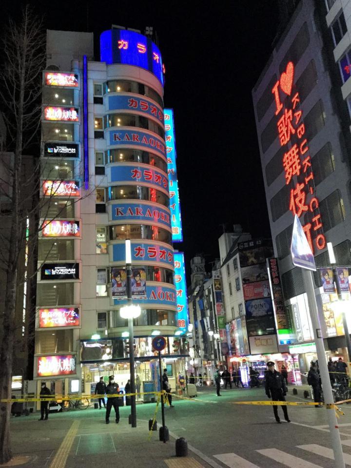 21日夜、発砲事件のあったカラオケ店（左）午前０時を過ぎても規制線が貼られたまま、捜査は続いた