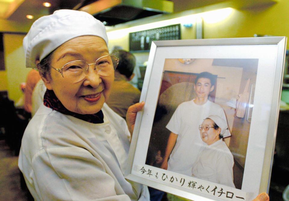 イチローとのツーショットを手にする初代店主の故・小林あや子さん（2004年撮影）。この写真は今も店内に飾られている