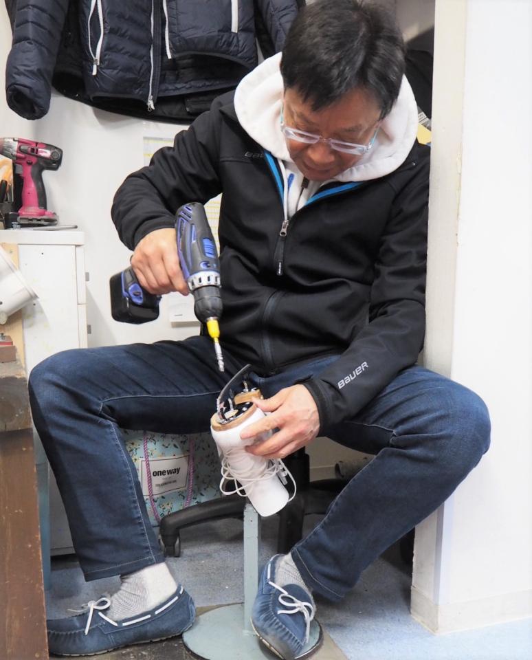 真剣な表情でスケート靴のメンテナンスをする田山さん