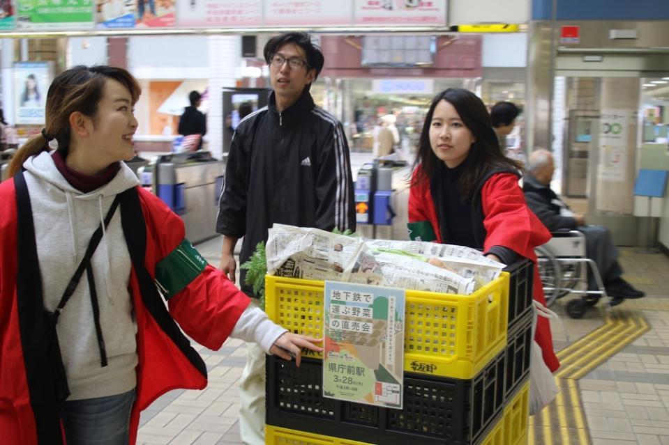 地下鉄に野菜のコンテナを運び込む竹下さんら＝神戸市営地下鉄西神中央駅
