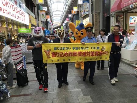 防犯キャンペーンで商店街をパレードする初代タイガーマスク（左から２人目）＝都内の十条銀座商店街