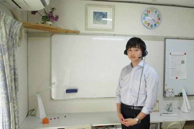 web塾ko-ko代表の田上裕太さん。ホワイトボードを使って、生徒との１対１のオンライン授業を行う