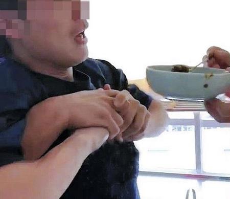 羽交い締めにされて激辛カレーを無理やり食べさせられる男性教員（提供写真、画像の一部を加工しています）