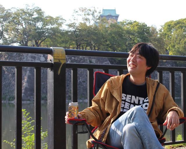 「今年は本が出たし、CDも出せた。もう人生終わった感があります」。大阪城の天守閣をバックに笑顔で語るスズキナオさん＝大阪城公園にて