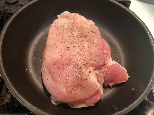 つめたいままのフライパンに鶏ムネ肉の皮目をぴったり貼りつけて塩胡椒したら、火をつけます。あくまで弱火です／イナダシュンスケさん提供