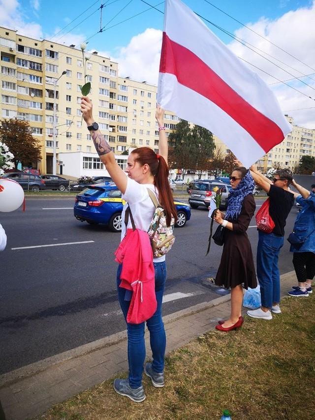 闘争の象徴とされる「白赤白の旗」を振る女性