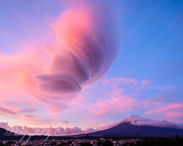 18日午前5時半ごろに撮影された、ピンクや紫に染まった「吊るし雲」＝富士山写真家オイ（@fujitomo_photo）さんのツイートより