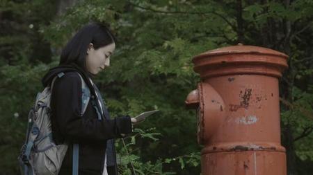 映画「漂流ポスト」のワンシーン。ポストの前で手紙を手にする主役の雪中梨世 (Ｃ) Kento Shimizu