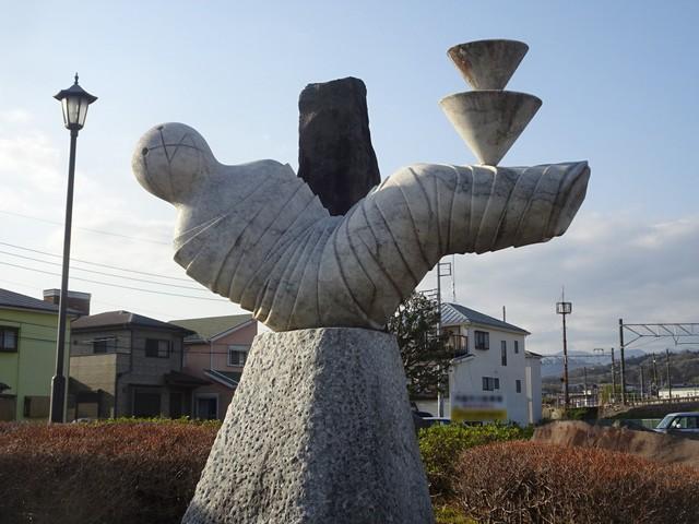 ＪＲ下曽我駅前ロータリーにあるオブジェ。足の上に乗る物体は「2つの独楽」だった＝神奈川県小田原市内