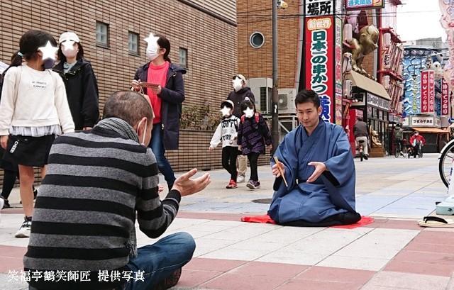 『時うどん』を辻立ち稽古する笑福亭鶴笑師匠と弟子の笑生さん。場所は新世界