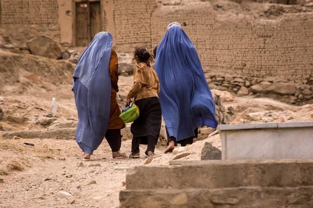 カブール近くの墓地を歩くブルカの女性と少女（timsimages.uk/stock.adobe.com）