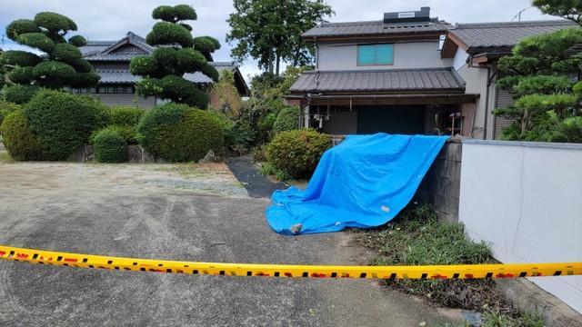 佐賀県鳥栖市で女性が殺害された現場。規制線の右奥、被害者が倒れていた場所にブルーシートが掛けられていた（撮影・小川泰平）