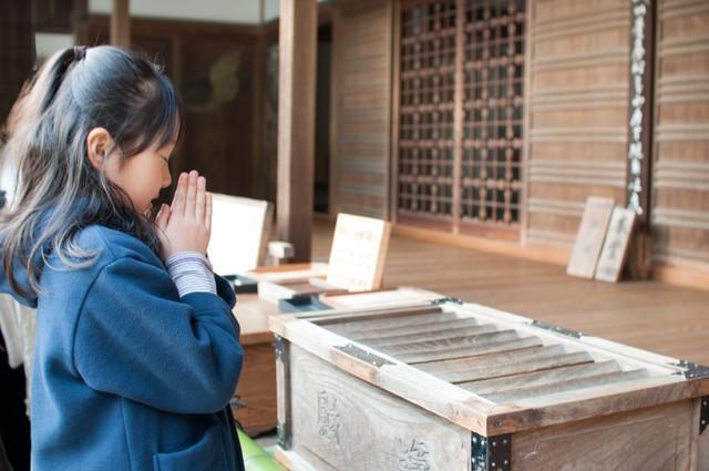 神社で願い事をする女の子(boarder/stock.adobe.com)