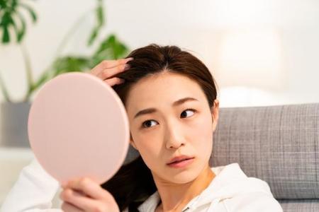 ヘアスタイルをチェックする女性のイメージ（miya227/stock.adobe.com）