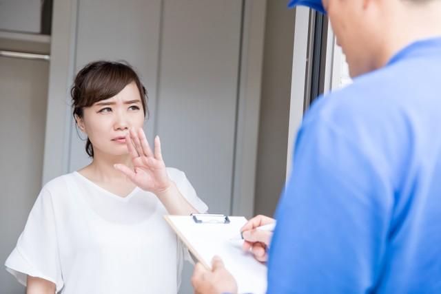 作業員の訪問に困った様子の主婦（buritora/stock.adobe.com)