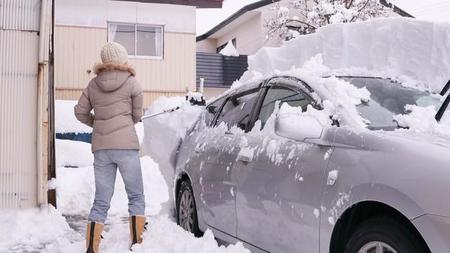 自動車の屋根の雪を降ろす女性　※写真はイメージです（kelly marken/stock.adobe.com）