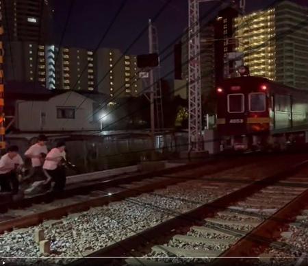 阪急電車が通り過ぎるや飛び出した撮り鉄たち（左）（提供動画より）