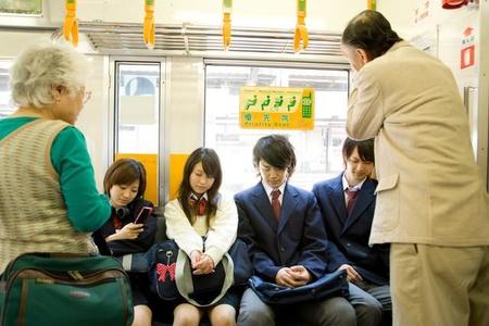 電車の優先席に座る高校生（TAGSTOCK2/stock.adobe.com)