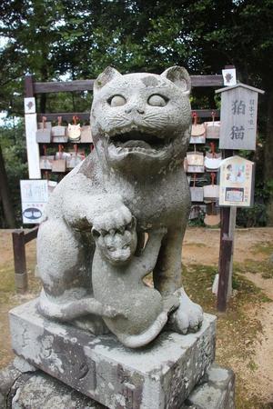 一対の狛猫のうち、子猫を抱く猫（京都府京丹後市峰山町泉・金刀比羅神社）