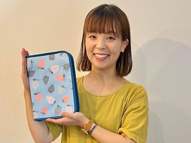 「づんの家計簿 A5バインダーポーチ」を手にするづんさん（宝島社提供）