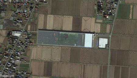 田んぼの中にあるプールのように見える建造物は野菜工場　（C）Google