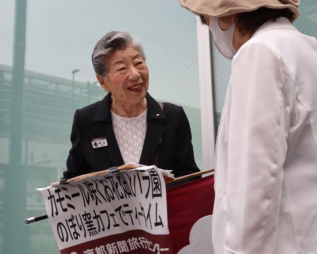 ツアーの参加者に笑顔で対応する井上さん（５月３１日、京都市南区・京都駅南口）