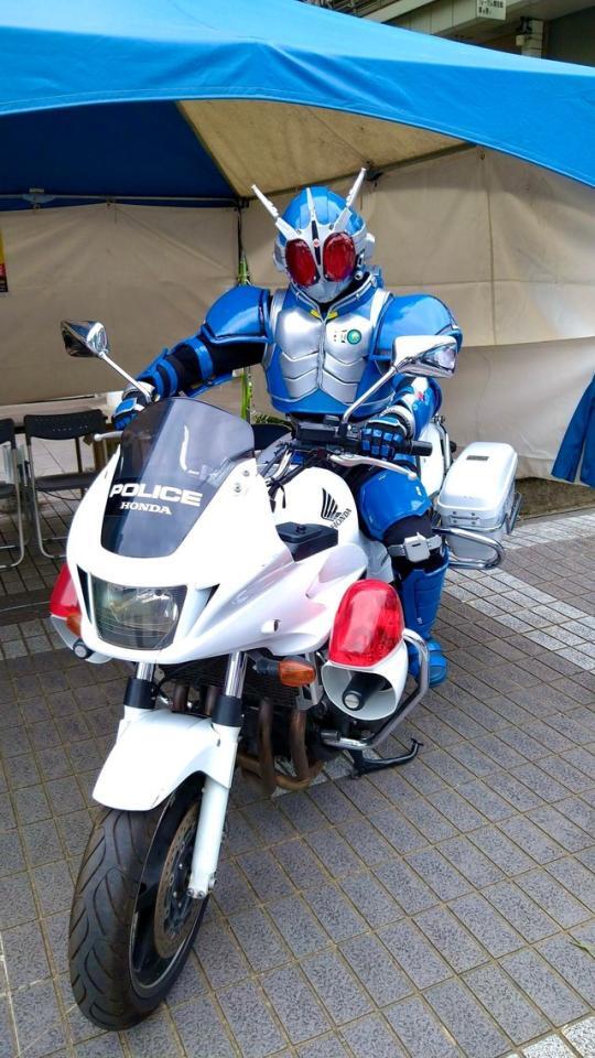 「仮面ライダーG3」のコスプレ姿で、本物の白バイにまたがる男性。警察官から大好評だったそう（提供）