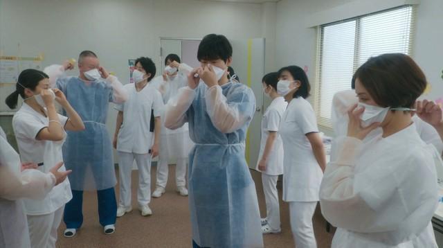 防護服の着方のレクチャーを受ける看護師の桑原（妃海風）、消化器内科医の森下（馬場徹）ら感染エリア担当の医療スタッフたち　(C)NHK