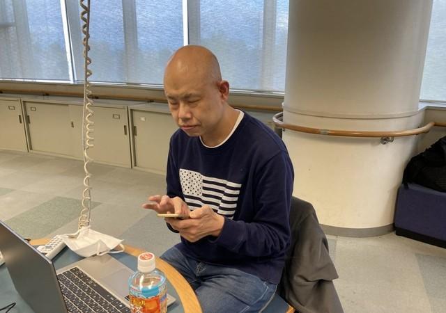 スマートフォンを操作する小川さん