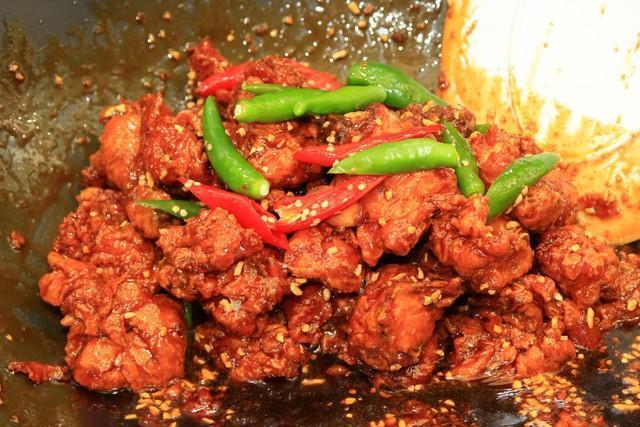 B級グルメの宝庫「新浦国際市場」で食べられる甘辛チキン「タッカンジョン」。サクサク衣に揚げた鶏肉に甘辛ソースを絡めた一品＝韓国・仁川