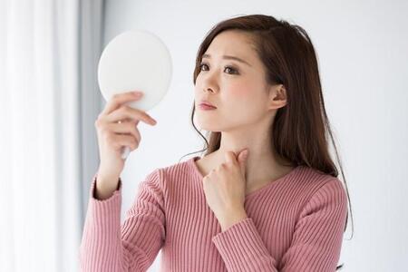 鏡を見て考えている女性※画像はイメージです（kei907/adobe.com/）
