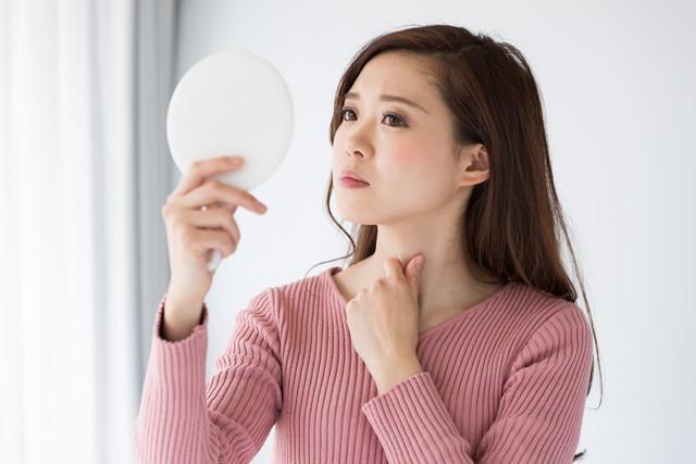 鏡を見て考えている女性※画像はイメージです（kei907/adobe.com/）