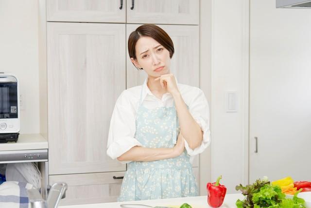 キッチンで悩む女性　※画像はイメージです （siro46/stock.adobe.com）