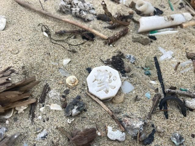 砂浜に落ちていたチャンギの駒。八角形で文字が刻まれている／Dennyさん（@De2_trash_rush）提供＝画像をトリミングしています