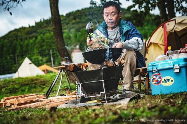 焚火で中華鍋を振る坂本明夫（近藤芳正／画像提供：シネマズギックス）