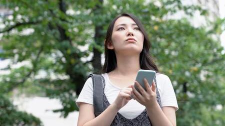 スマホの充電が切れそうで不安になっている女性※画像はイメージです。（taka/stock.adobe.com/）