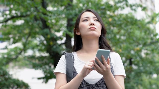 スマホの充電が切れそうで不安になっている女性※画像はイメージです。（taka/stock.adobe.com/）