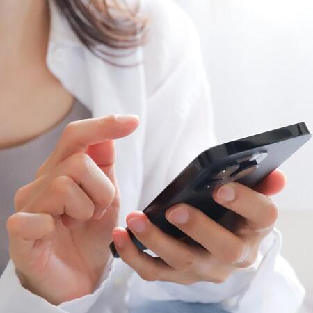 スマートフォンを見る女性　※画像はイメージです（webbiz/stock.adobe.com）