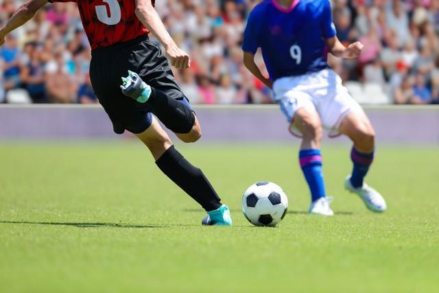 サッカーの試合でボールを蹴る選手※画像はイメージです（D maborosi/stock.adobe.com）
