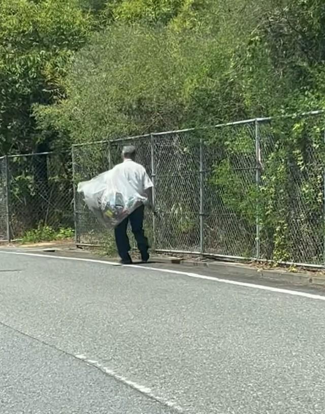 道路脇で、大きな袋を抱えながら歩く」ワイシャツにスラックス姿の男性の姿が…